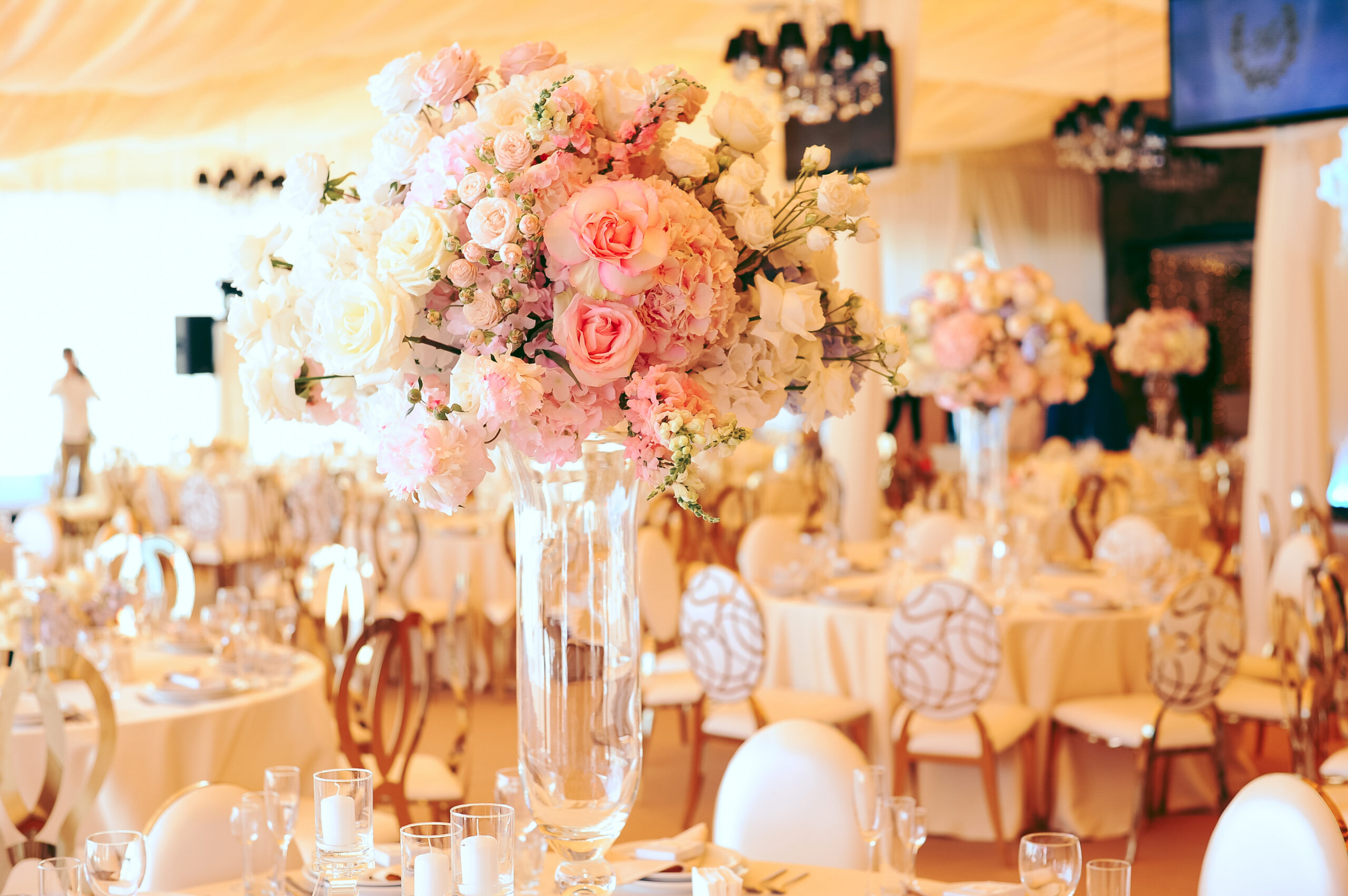 flower centerpiece bouquets with white and pink eustomas in the glass vases on the table